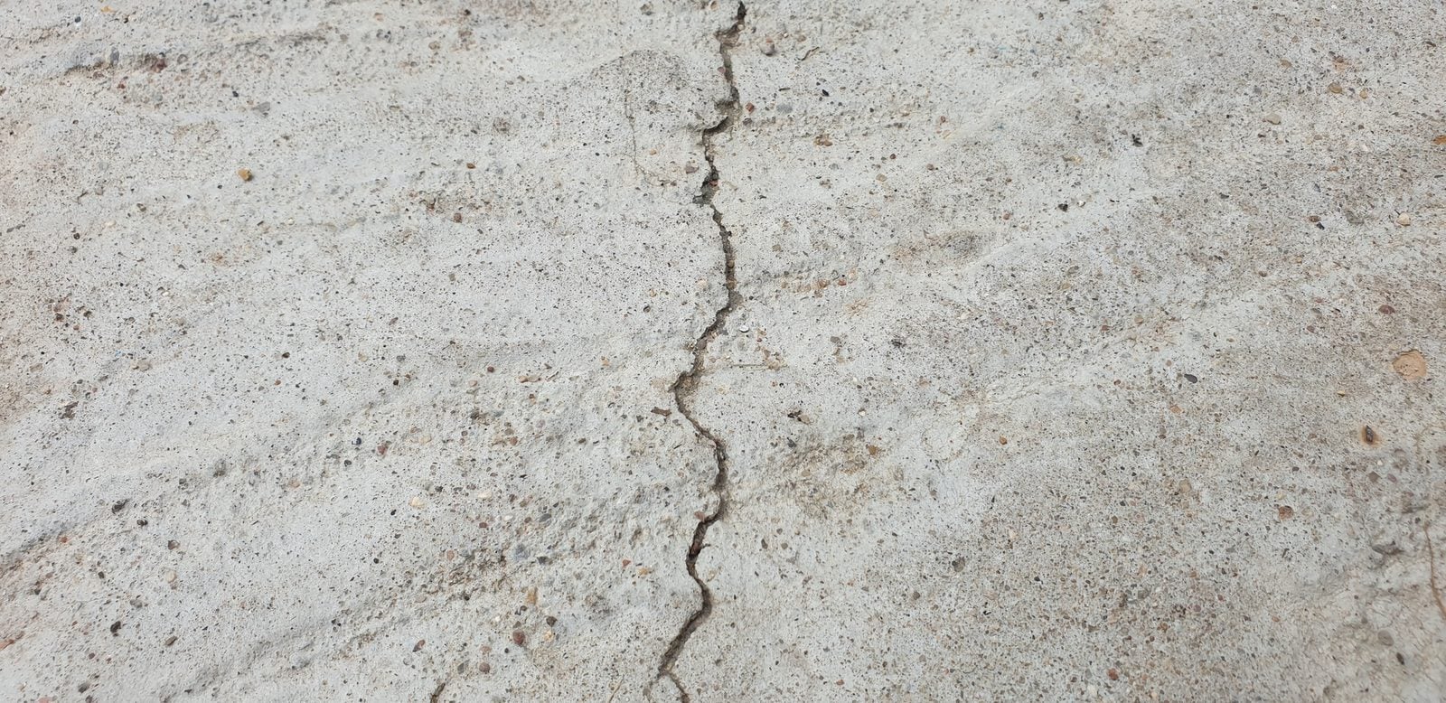 Thin crack running through a concrete slab surface